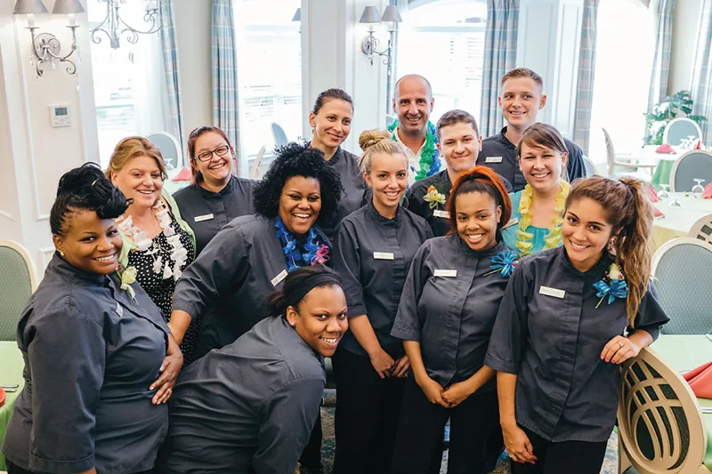 A group of staff is smiling and take a picture