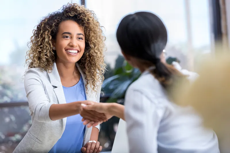 a sales woman shaking hands with a client